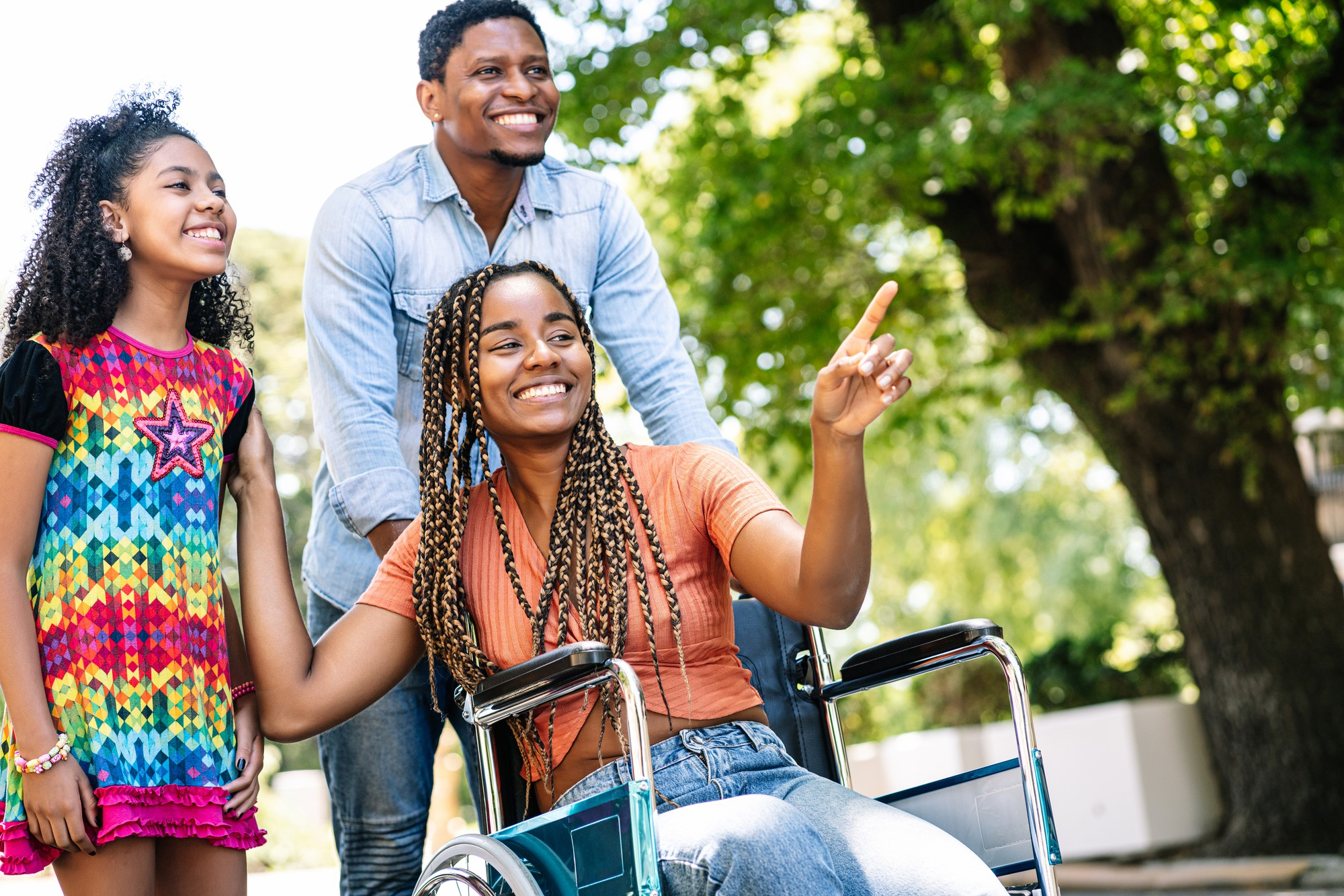 A family outdoors, including a woman using a wheelchair, reflecting inclusive programme design
