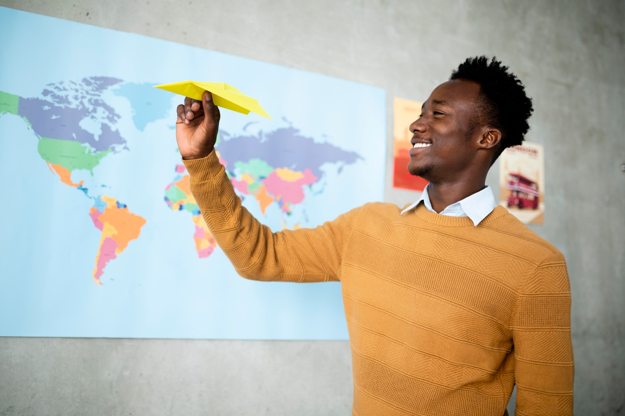 A young man with a world map behind him, suggesting a transferable programme model